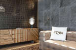 Luxury living room boasts a stylish wooden cabinet, complemented by a modern lamp and a comfortable sofa with a Fendi pillow.