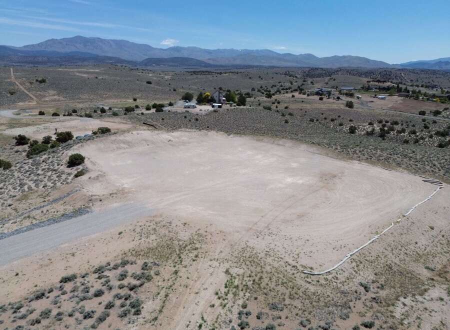 This property boasts a spacious, flat area perfect for various uses, bordered by a thoughtfully placed erosion control system.