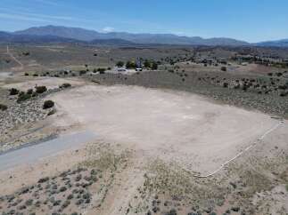 This property boasts a spacious, flat area perfect for various uses, bordered by a thoughtfully placed erosion control system.