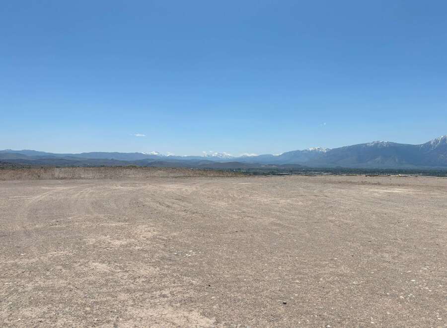 This expansive property boasts breathtaking views of snow-capped mountains and a vast, open landscape.