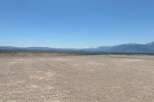 This expansive property boasts breathtaking views of snow-capped mountains and a vast, open landscape.