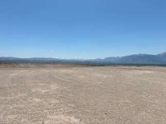 This expansive property boasts breathtaking views of snow-capped mountains and a vast, open landscape.