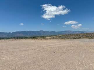This stunning property boasts breathtaking views of the majestic mountains and a vast expanse of clear blue sky.