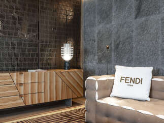 Luxury living room boasts a stylish wooden cabinet, complemented by a modern lamp and a comfortable sofa with a Fendi pillow.