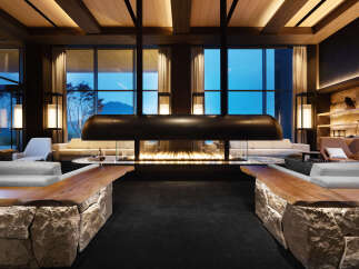 Luxurious lodge with floor-to-ceiling windows offering breathtaking mountain views.