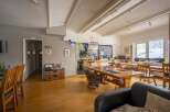 Cozy communal space with wooden dining tables and chairs, perfect for socializing.
