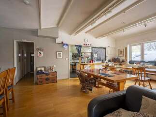 Cozy communal space with wooden dining tables and chairs, perfect for socializing.