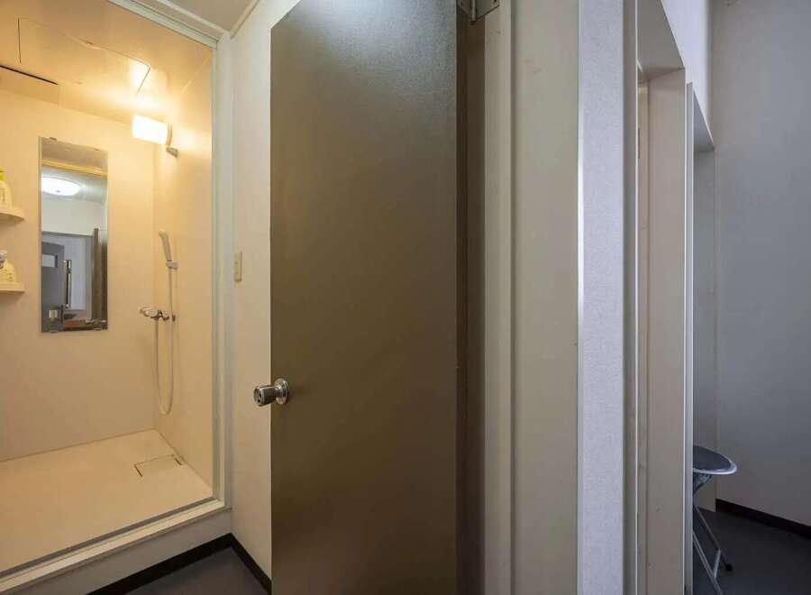 This cozy apartment features a compact yet functional shower stall, perfect for quick and easy morning routines.