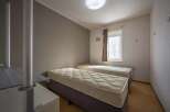 Cozy twin bedroom with neutral wall tones and natural light from a window.