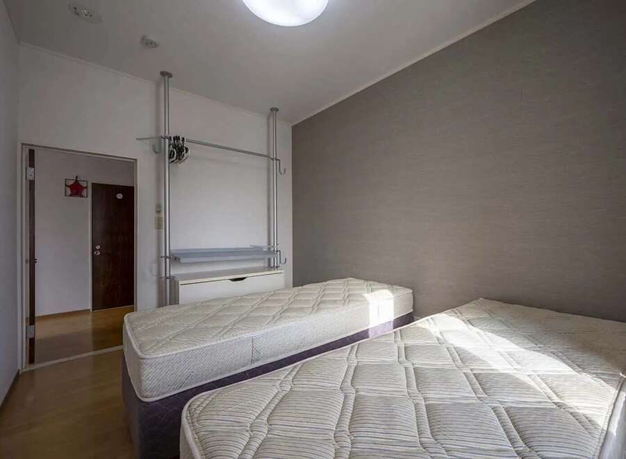 Cozy twin bedroom with built-in closet and neutral wall tones.