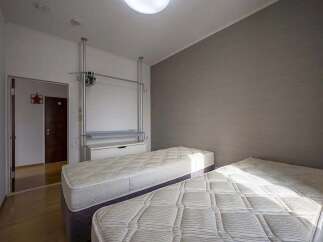 Cozy twin bedroom with built-in closet and neutral wall tones.