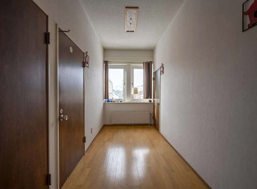 This hallway boasts light wood flooring and neutral walls, creating a bright and airy atmosphere.