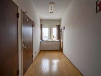 This hallway boasts light wood flooring and neutral walls, creating a bright and airy atmosphere.