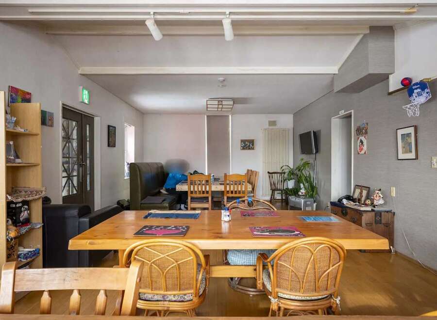Cozy communal dining area with a large wooden table and wicker chairs, perfect for guests to gather and socialize.