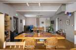 Cozy communal dining area with a large wooden table and wicker chairs, perfect for guests to gather and socialize.