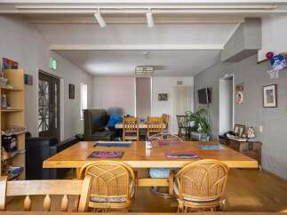 Cozy communal dining area with a large wooden table and wicker chairs, perfect for guests to gather and socialize.