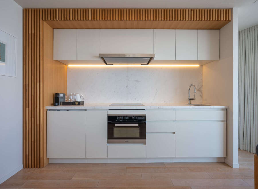 Modern kitchen with sleek white cabinets and integrated appliances.