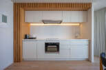 Modern kitchen with sleek white cabinets and integrated appliances.
