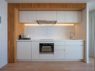 Modern kitchen with sleek white cabinets and integrated appliances.