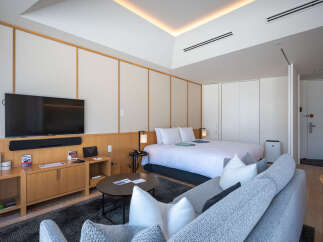 This modern hotel room boasts a comfortable king-size bed, a sleek flat-screen TV, and a cozy seating area perfect for relaxing.