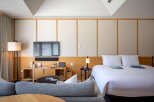 Relax in style in this modern hotel room, featuring a comfortable bed, flat-screen TV, and cozy seating area.