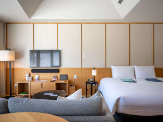 Relax in style in this modern hotel room, featuring a comfortable bed, flat-screen TV, and cozy seating area.