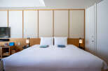 This hotel room boasts a king-size bed with crisp white linens, perfect for a relaxing stay.
