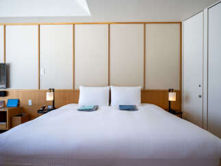 This hotel room boasts a king-size bed with crisp white linens, perfect for a relaxing stay.