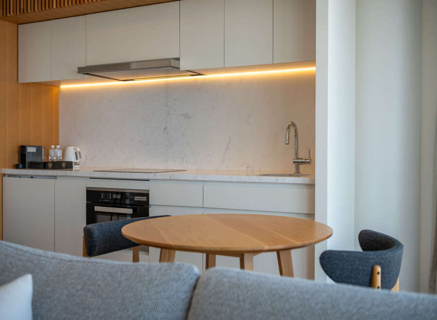 Modern kitchen with marble countertops and wooden accents.