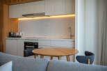 Modern kitchen with marble countertops and wooden accents.