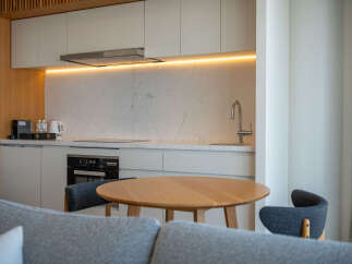 Modern kitchen with marble countertops and wooden accents.