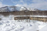 Nestled in a snowy mountain landscape, this charming lodge offers breathtaking views and cozy accommodations.