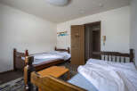 Cozy twin room with two wooden beds, offering a simple and comfortable stay.