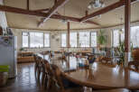 This cozy restaurant boasts a rustic charm with exposed wooden beams and large windows offering scenic views.