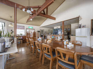 This cozy lodge boasts a large communal dining table perfect for group gatherings, featuring a rustic wooden design and comfortable seating.