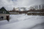Cozy cabin nestled in a snowy mountainside, perfect for a winter getaway.
