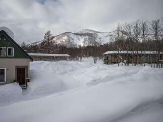 Cozy cabin nestled in a snowy mountainside, perfect for a winter getaway.