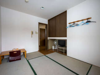 This cozy room features tatami mats, a built-in closet, and a small desk.