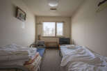 Cozy twin room with two single beds, a small TV, and a heater.