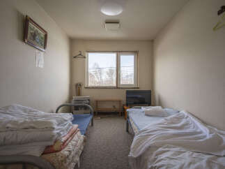 Cozy twin room with two single beds, a small TV, and a heater.