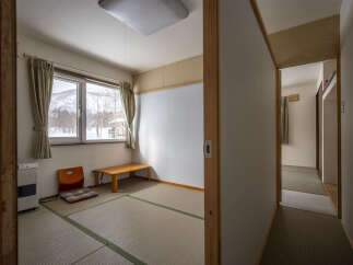 Cozy Japanese-style room with tatami mats, offering a serene atmosphere and mountain views.
