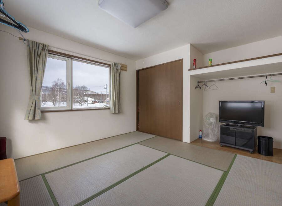 This cozy room features tatami mats, a window with mountain views, and built-in closet space.