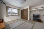 This cozy room features tatami mats, a window with mountain views, and built-in closet space.
