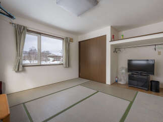 This cozy room features tatami mats, a window with mountain views, and built-in closet space.