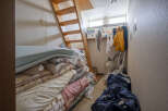 Cozy attic room with wooden ladder access, offering ample storage space.