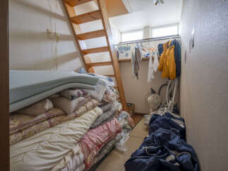 Cozy attic room with wooden ladder access, offering ample storage space.