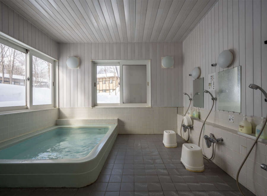 Relax and rejuvenate in this serene onsen, featuring a spacious bathtub perfect for soaking in the soothing waters.