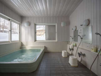 Relax and rejuvenate in this serene onsen, featuring a spacious bathtub perfect for soaking in the soothing waters.