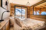 Wake up to breathtaking mountain views from this cozy chalet bedroom.