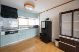 This charming kitchen boasts modern light teal cabinets, stainless steel countertops, and a built-in oven.